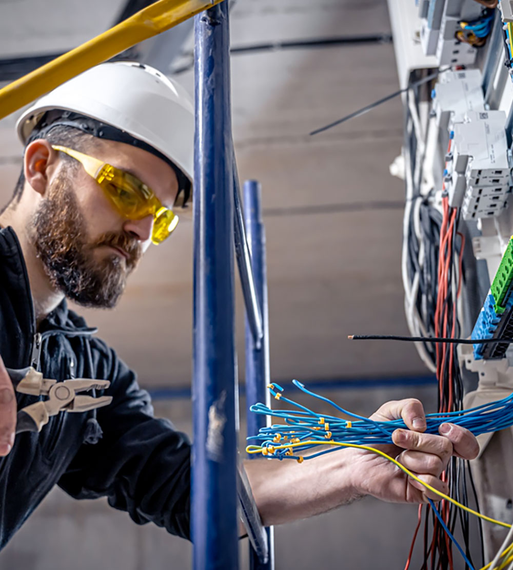 man in hard hat and goggles clamping cables