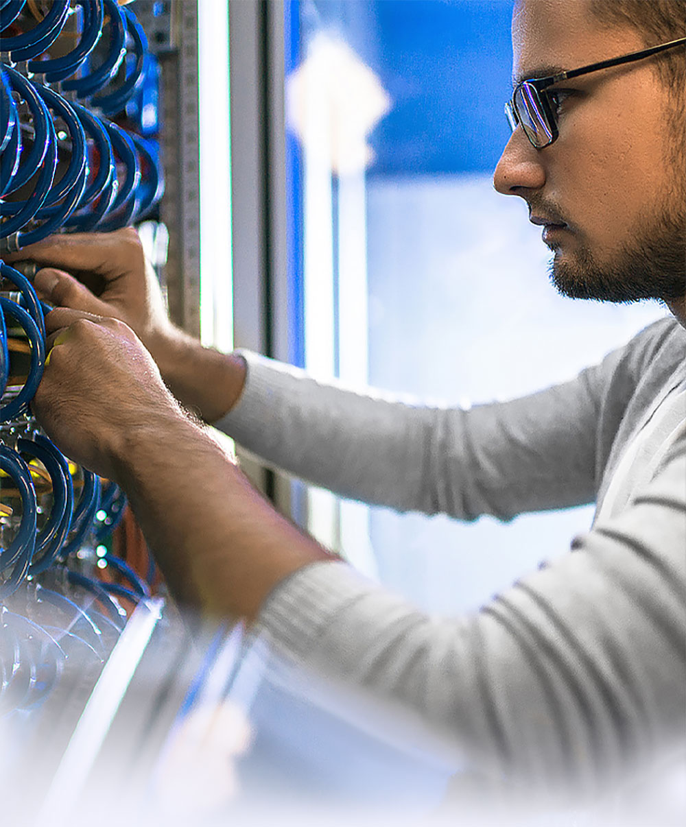 man with glasses looking at blue cabling