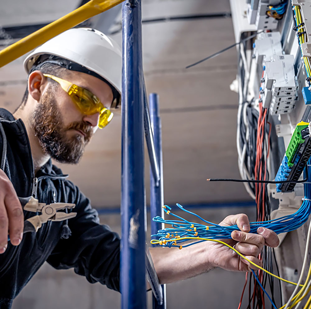 man with hard hat and safety goggles wire installation