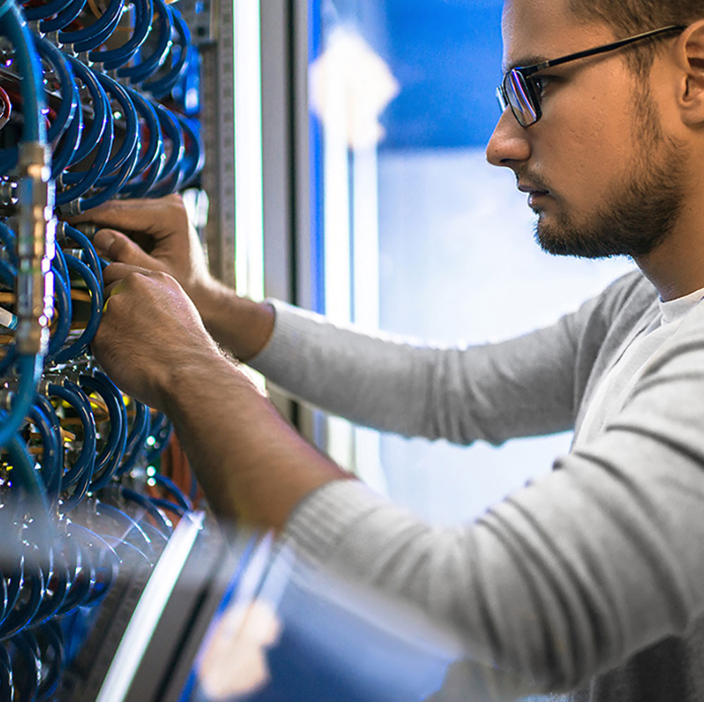 man with glasses checking wires